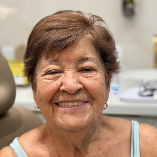 Paciente sorrindo na cadeira do consultório.